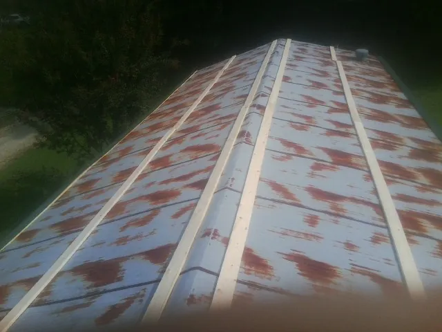 Rusted metal roof panels with new wood purlins before replacement — Storm Damage Roof Repair in Plum Branch by Roofing Brothers