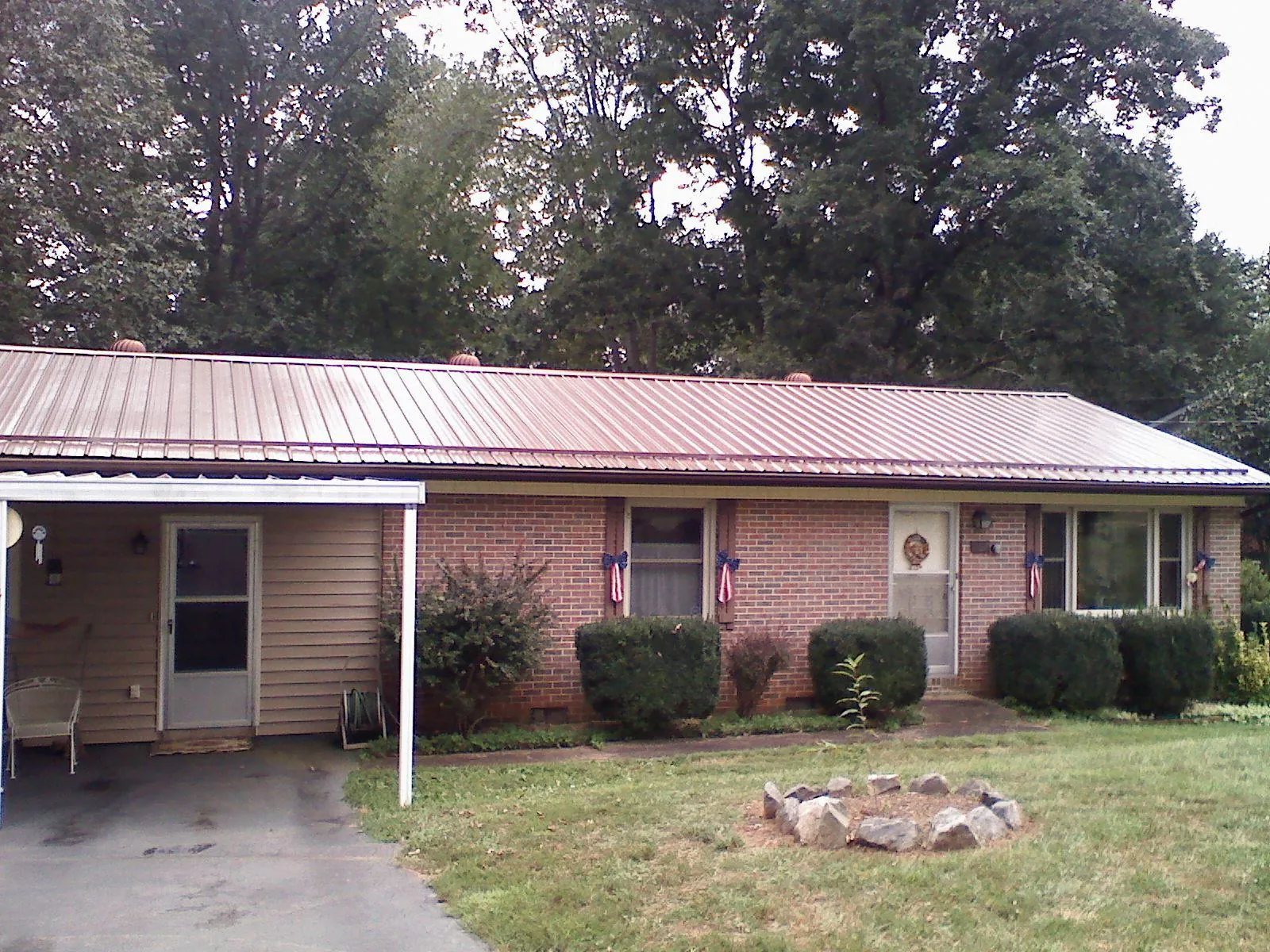 Bronze metal roof and carport on a brick ranch home — Roof Repair work by our crew in Plum Branch